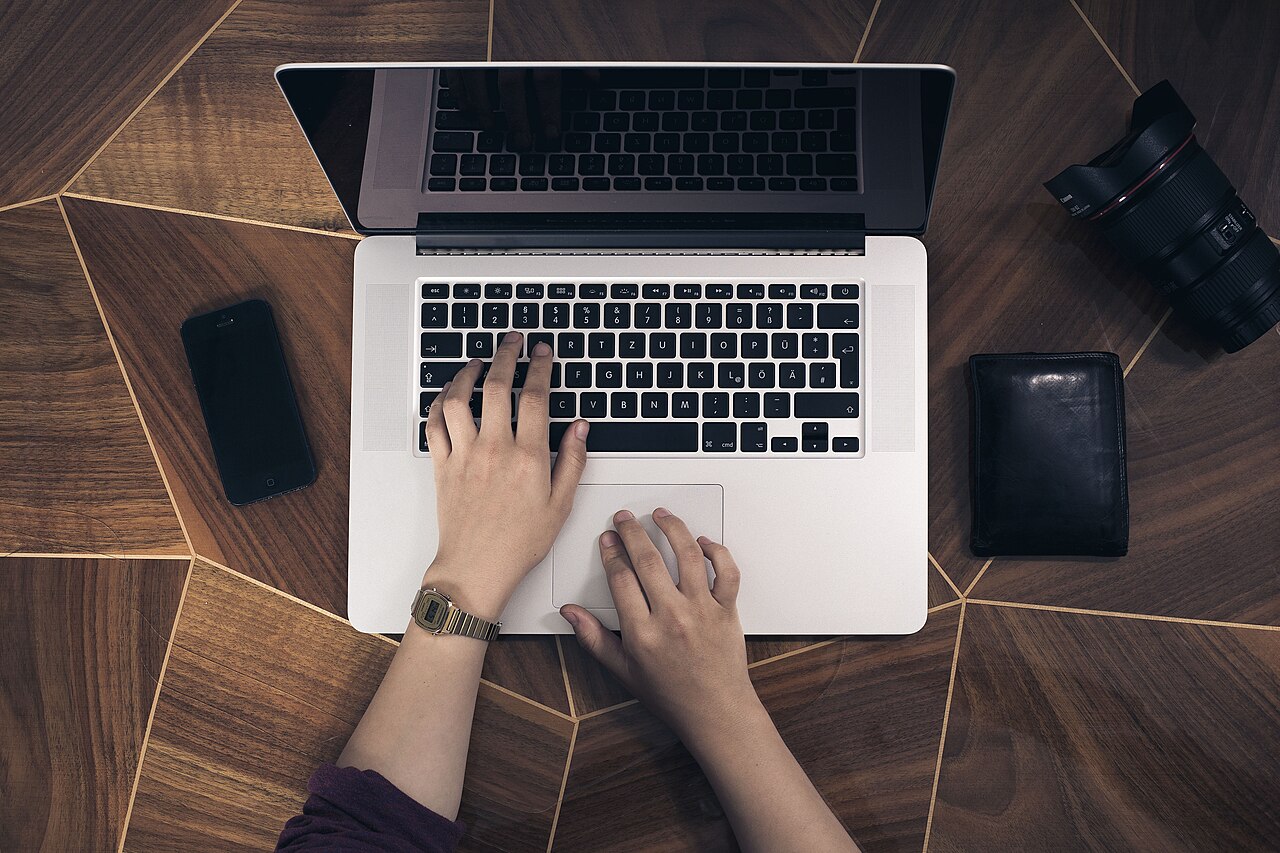 Hands typing on a laptop keyboard